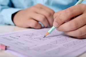 Hands and pencil with multiple choice test paper